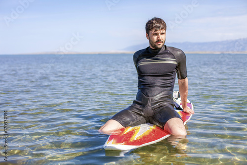 Surfer sitting on surfboard photo