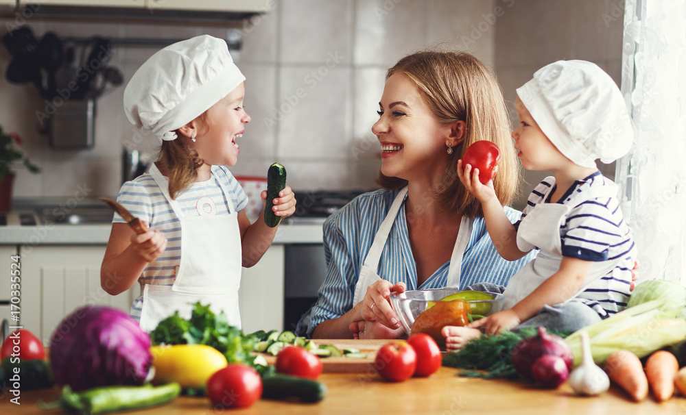 Healthy eating. Happy family mother and children prepares vegetable salad in kitchen. Healthy eating. Happy family mother and children prepares vegetable salad in kitchen.