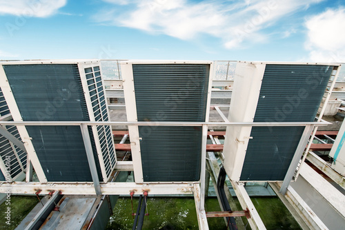 Industrial air conditioner condensers (outside unit) on the roof of a building on a hot summer day photo