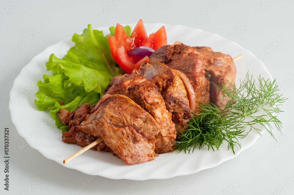 Beef pork barbecue kebab on skewer on a white plate Beef pork barbecue kebab on skewer on a white plate