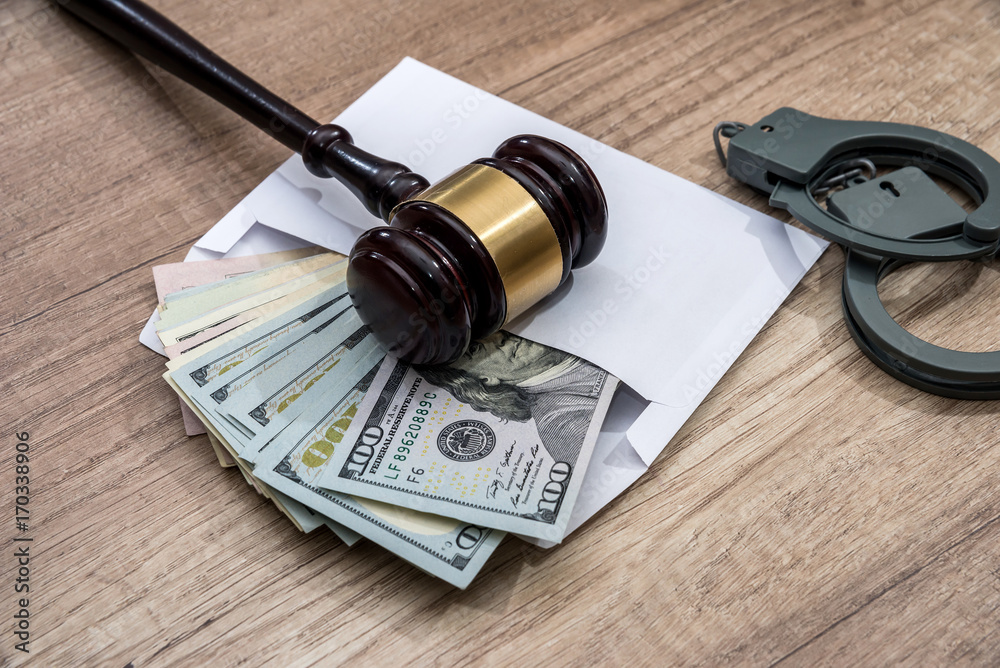 The concept of corruption - dollars in an envelope, handcuffs and hammer judges
