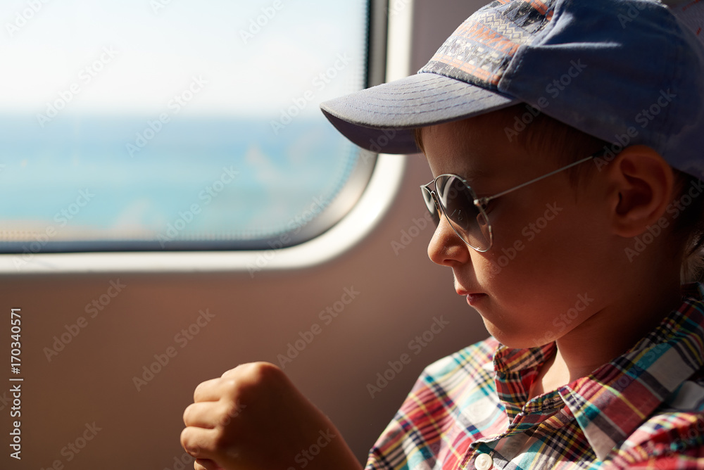 Cute boy travelling by train.