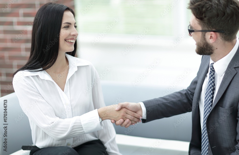 handshake of manager and client sitting in the office lobby.
