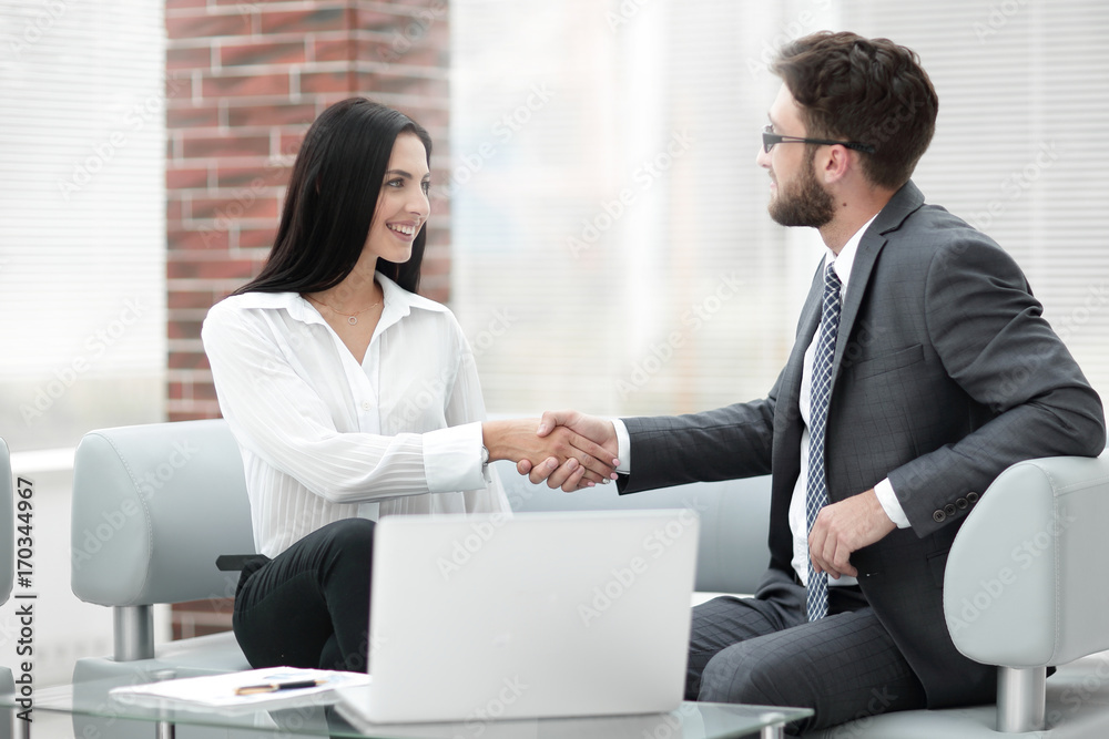 handshake of manager and client sitting in the office lobby. handshake of manager and client sitting in the office lobby.