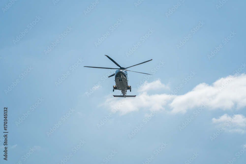 The helicopter is flying in the sky