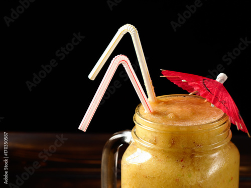 Fruity smoothies on a wooden table and black background. photo