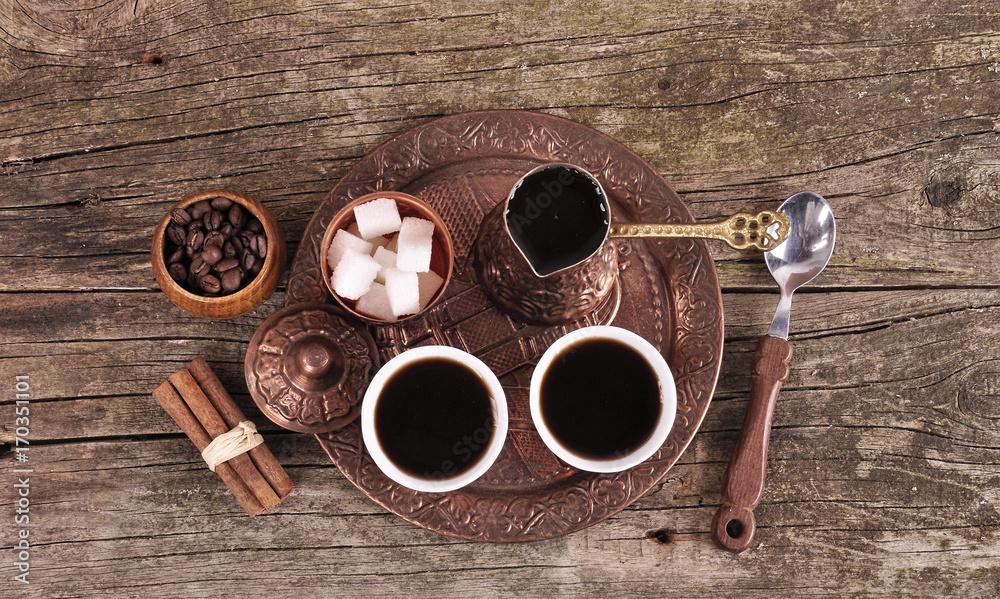 Coffee in copper coasters with accessories for coffee-drinking on old wooden background Coffee in copper coasters with accessories for coffee-drinking on old wooden background