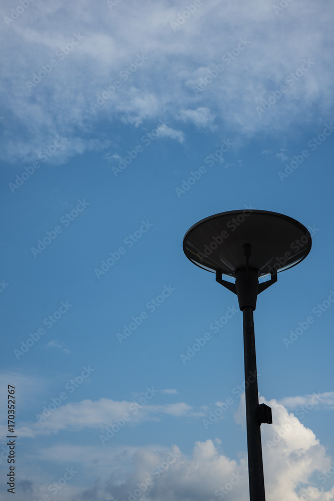 dark street light isolated with cloudy blue sky