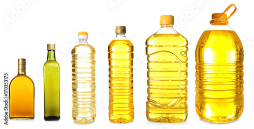 Different bottles with cooking oil on white background photo