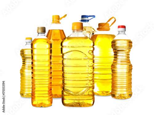 Different bottles with cooking oil on white background