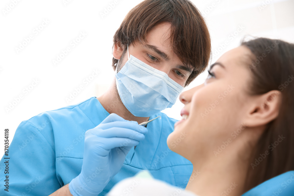 Dentist examining woman's teeth in clinic