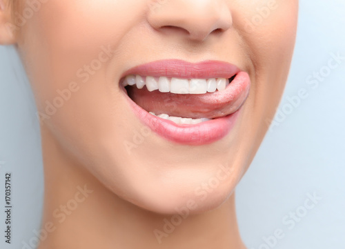 Young beautiful woman with healthy teeth smiling on light background