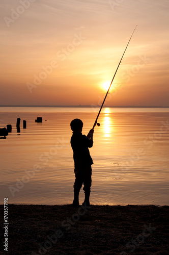 Silhouette of a boy fisherman