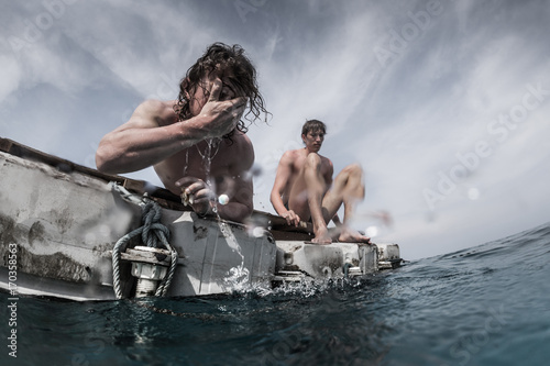 Two men floating in the tropical sea and waiting for resque
