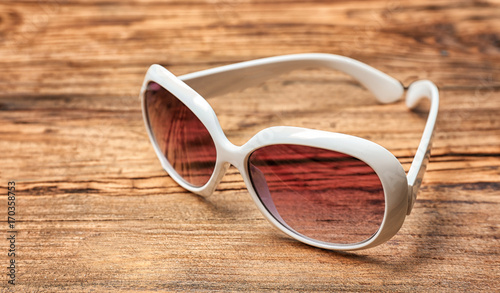 Beautiful sunglasses on wooden background