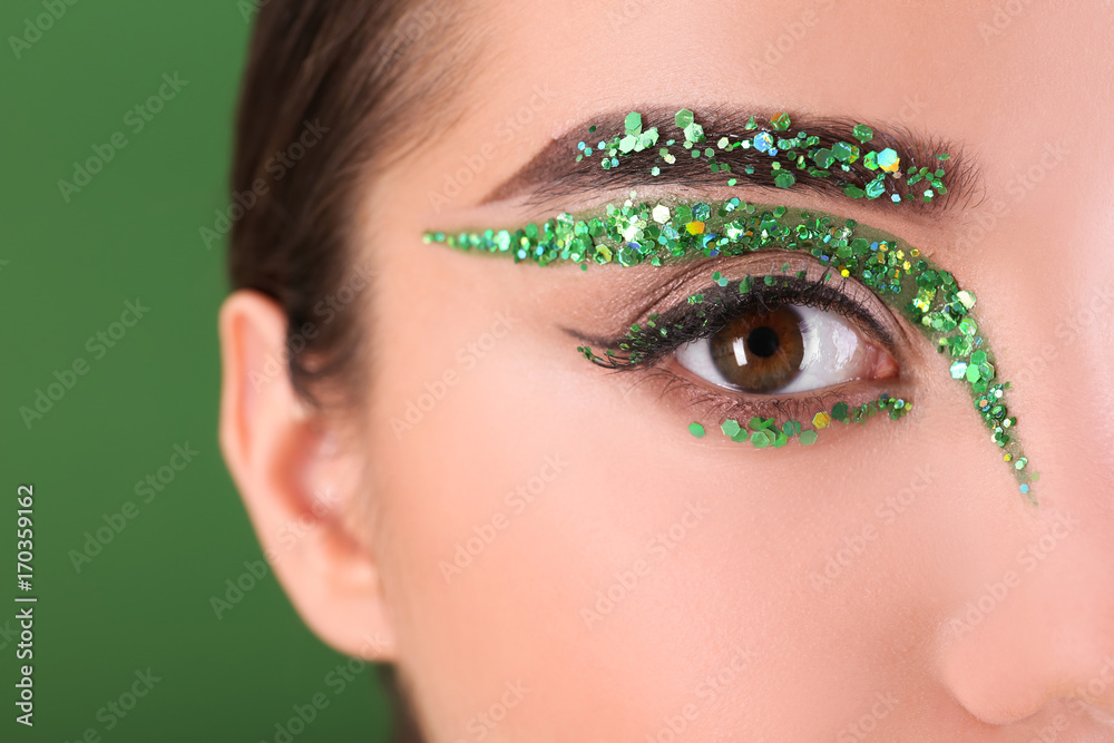 Fototapeta premium Young woman with creative makeup on color background, close up