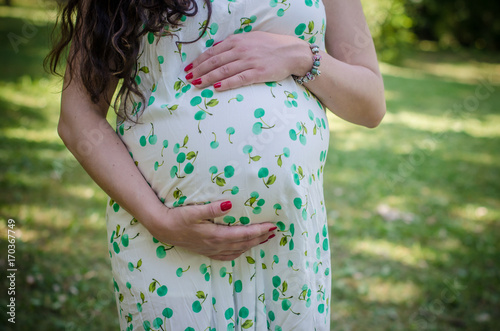 Close up of pregnant belly in summer dress