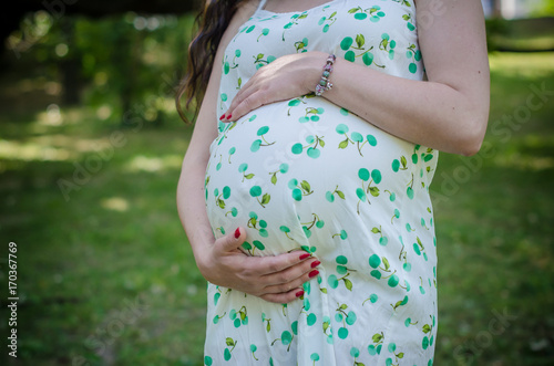 Close up of pregnant belly in summer dress