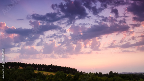 Colorful sunset clouds above the hill