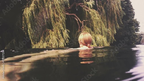 Woman swims in beautiful lake - Dreamy faded look