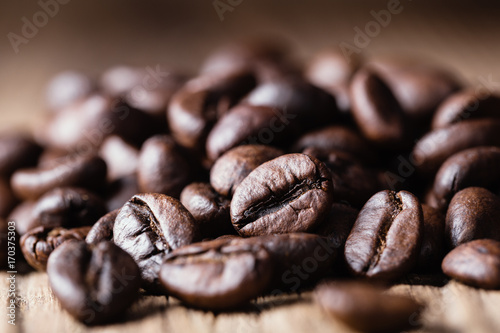 Roasted coffee beans on wooden background.