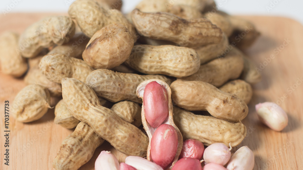 Peeled peanut on well peanuts,peanuts in the Wooden cup Peeled peanut on well peanuts,peanuts in the Wooden cup