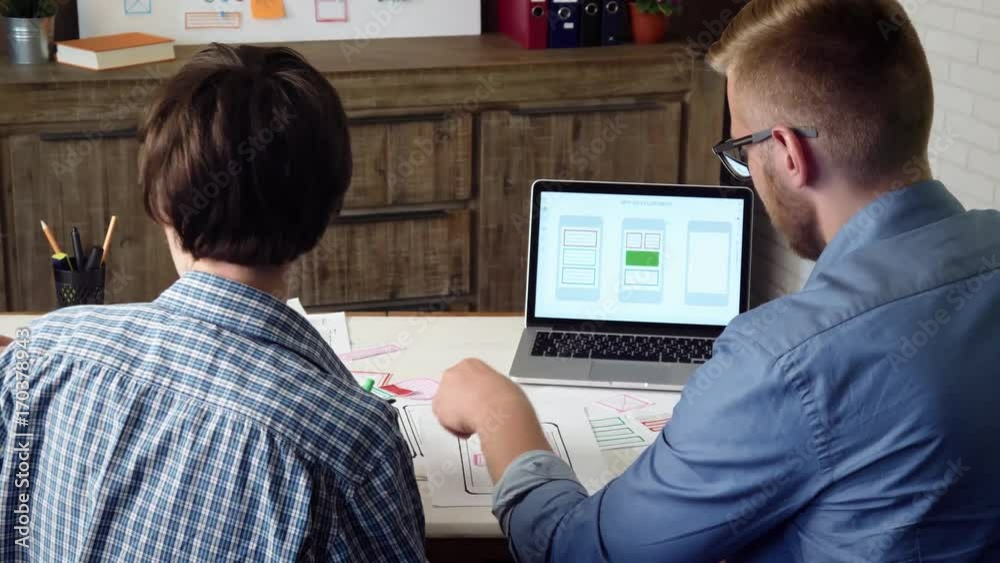 Mobile app designers developing smartphone application layout and giving high five