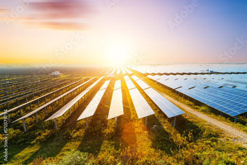 Photovoltaic modules reflect sunset light and clouds photo