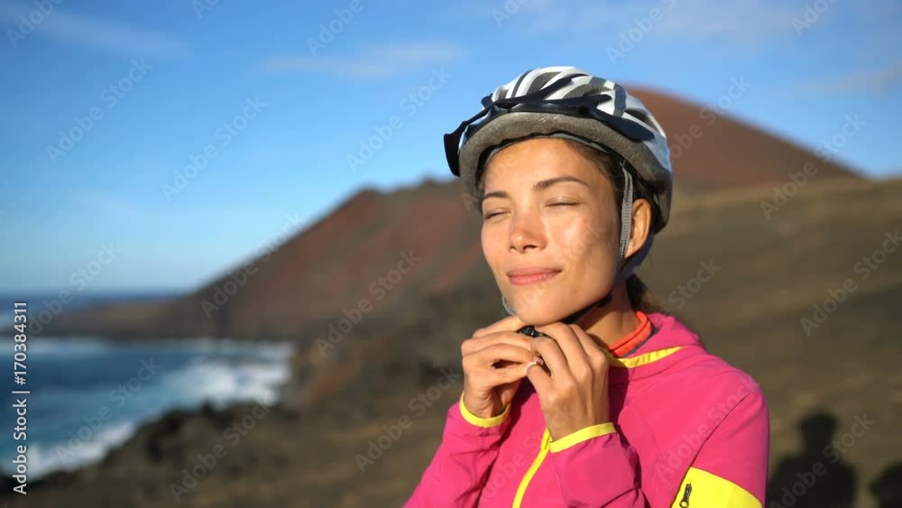 Woman cyclist putting on biking helmet while MTB mountain biking in nature. Girl living healthy active lifestyle. Woman cyclist putting on biking helmet while MTB mountain biking in nature. Girl living healthy active lifestyle.