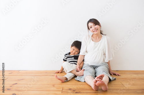 フローリングに座る男の子と妊婦さん