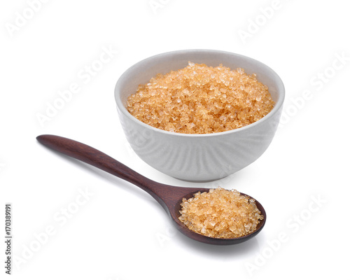 brown cane sugar in wooden spoonn and white cup isolated on white background photo