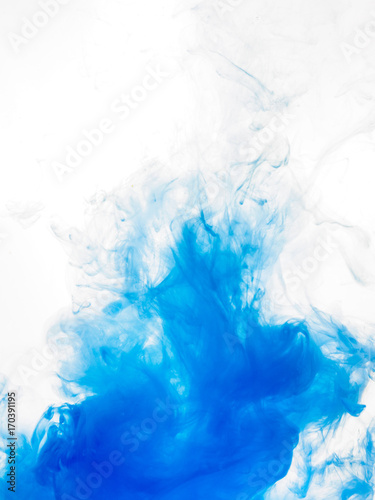 Ink swirl in water isolated on white background. The paint in the water. Soft dissemination a droplets of blue ink in water close-up. Abstract background. Soft focus. © eriksvoboda