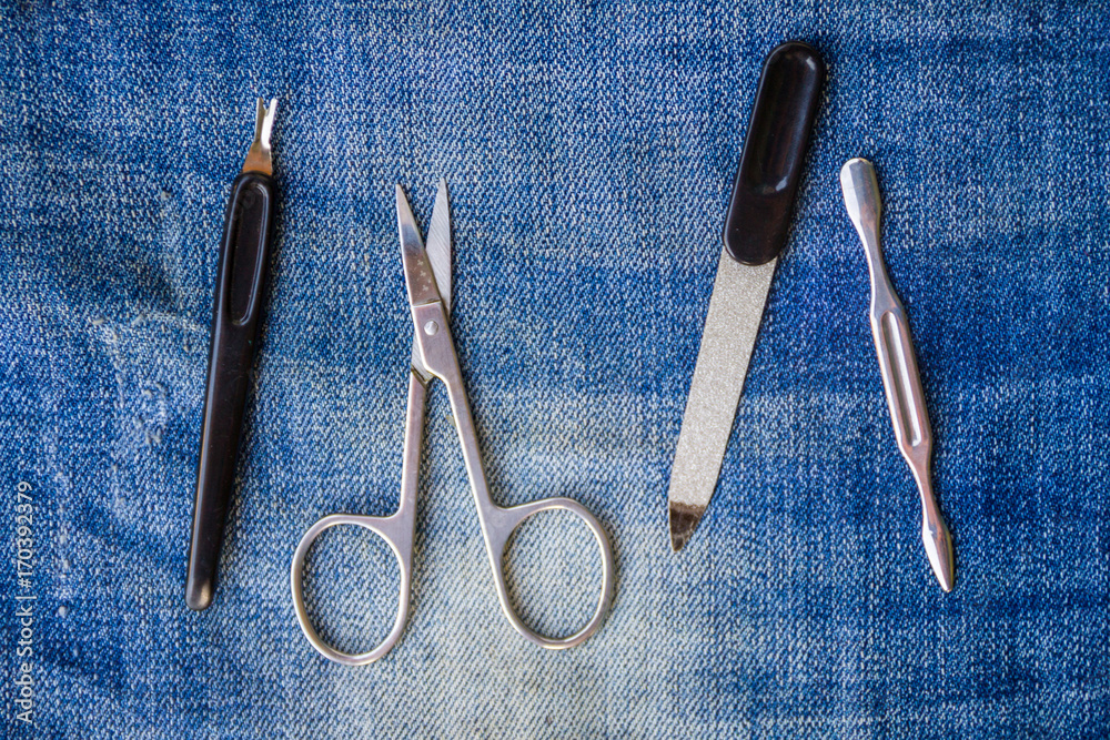 Basic set of manicure tools on jeans background Basic set of manicure tools on jeans background