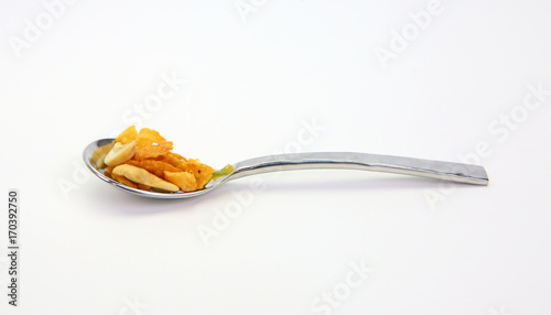 cereal with cashew nut and kiwi in a stainless spoon.