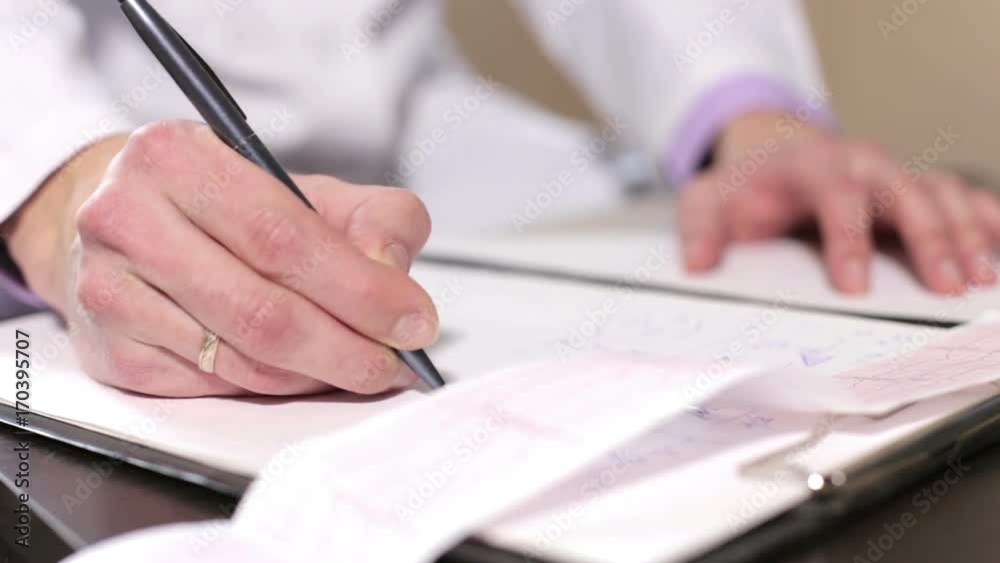 Doctor cardiologist takes notes of the results, the cardiogram heart Doctor cardiologist takes notes of the results, the cardiogram heart