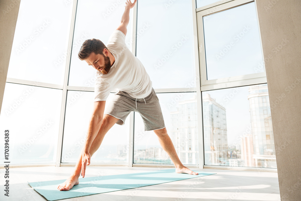 Fototapeta premium Bearded man warming up over window background