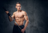 Shirtless male holds barbell.