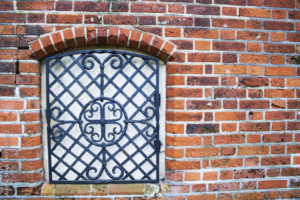 The wall with window of broken and abandoned red brick house.