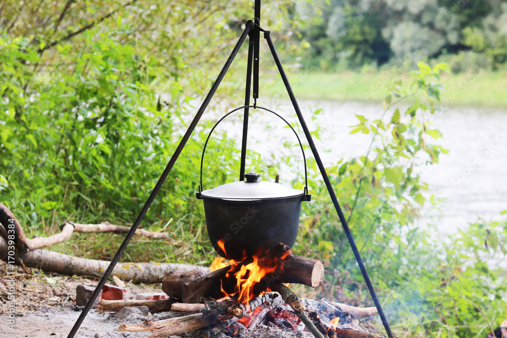 Cooking food in summer on nature at stake in cauldron Cooking food in summer on nature at stake in cauldron