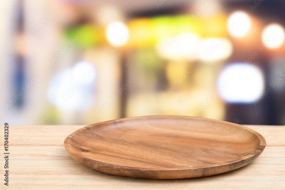 Empty wooden tray on perspective wooden table on top over blurcoffee shop background. Can be used mock up for montage products display or design layout.