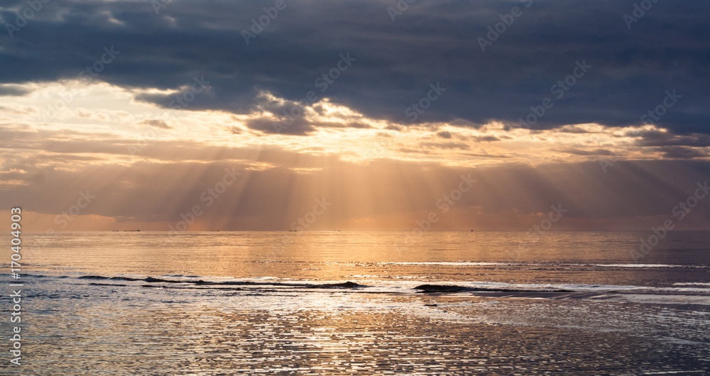 Obraz premium Sunset with clouds and sun rays at the Baltic Bay, Latvia