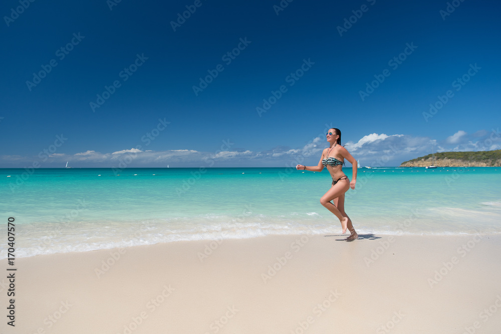 Woman in sexy swimsuit running on beach Woman in sexy swimsuit running on beach