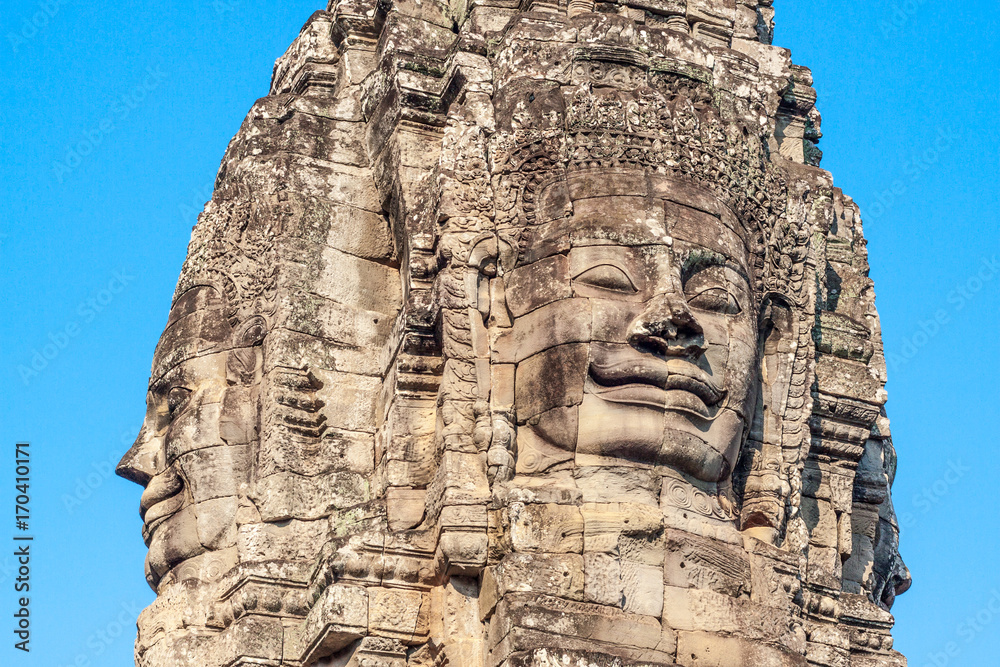 Ancient stone smiling face of the Bayon Wat temple in the jungle, Angkor wat, Cambodia. Angkor Wat isthe largest religious monument in the world.