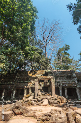 Ancient gallery of amazing Ta Prohm temple overgrown with trees. Mysterious ruins of Ta Prohm nestled among rainforest in Angkor, Siem Reap, Cambodia. Ta Prohm is also known as Tomb Raider © Fly Dragon Fly