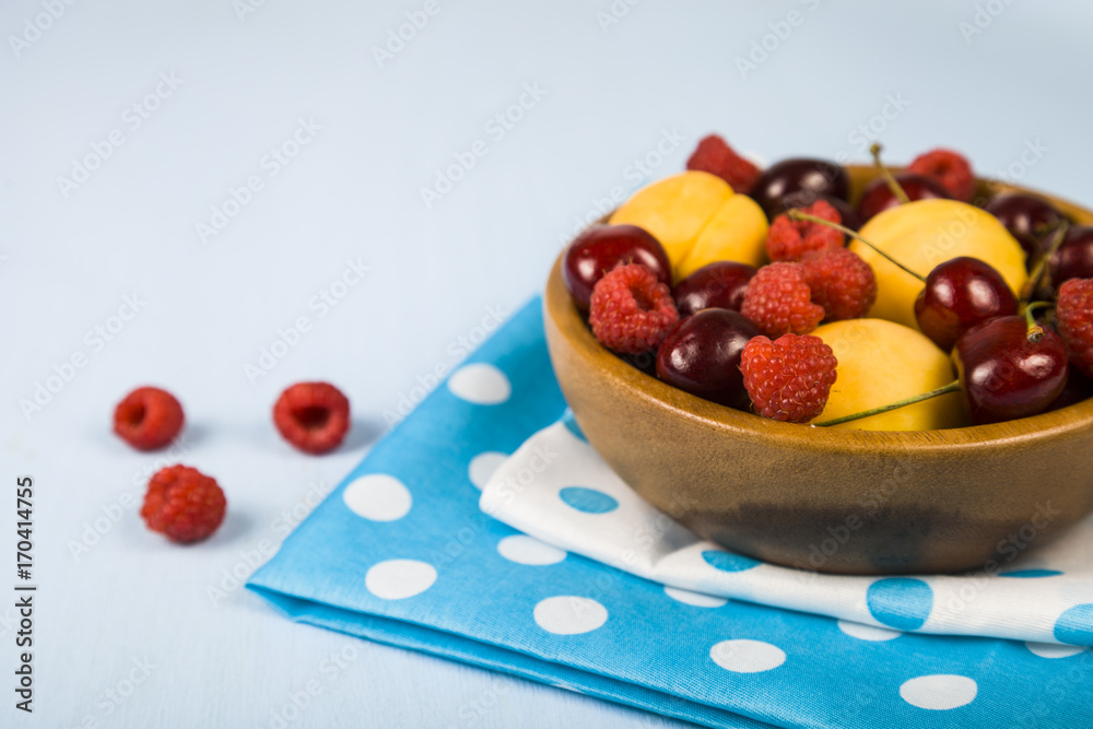 Ripe berries in a plate on a wooden table. Ripe berries in a plate on a wooden table.