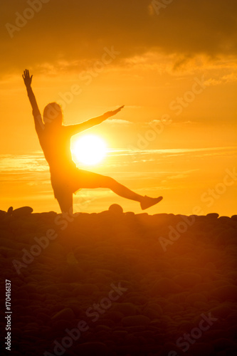 Yoga Woman doing yoga pose outside in sunset