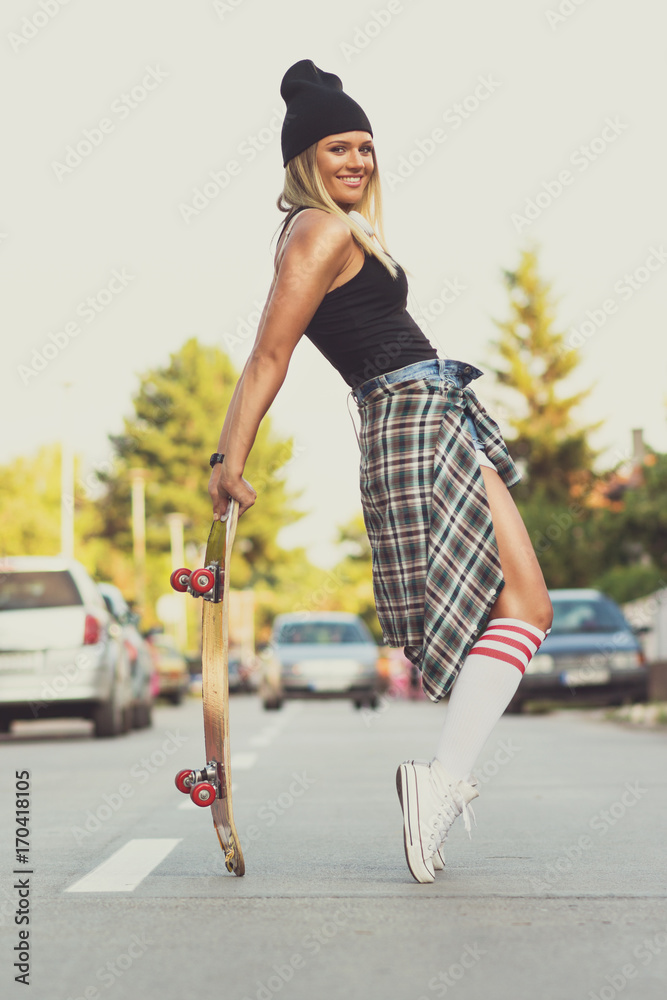 Cool skater girl posing with skate board in the street Stock Photo | Adobe  Stock