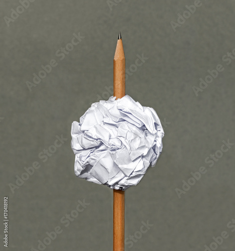 Pencil pierced the ball paper on gray background.