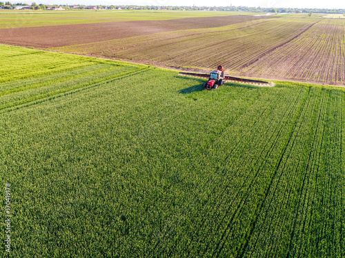 Farmer spraying green wheat field