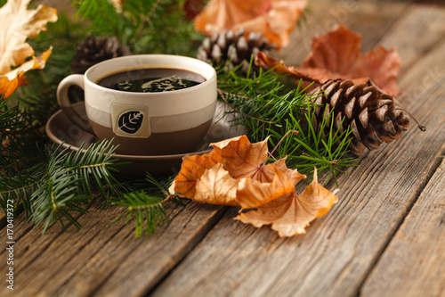 Fotografie Hot coffee and pine coneson on table wood background with copy space
